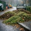 Debris-filled municipal pathway with leaves, hedge trimmings and wet grass clippings needing vacuum loading